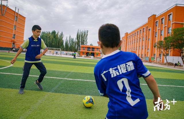 明德小学的学生在练习足球,球衣上写着“广东援疆”的字样。 明德小学的学生在练习足球,球衣上写着“广东援疆”的字样。