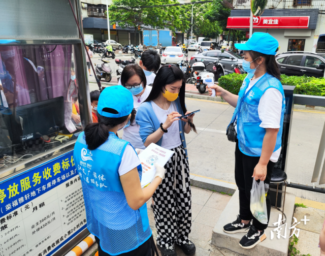 党员志愿者在街道协助测量体。 党员志愿者在街道协助测量体。