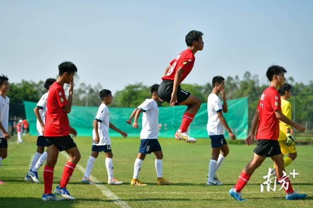 比赛即将开始,清远队球员在进场中跳跃热身。