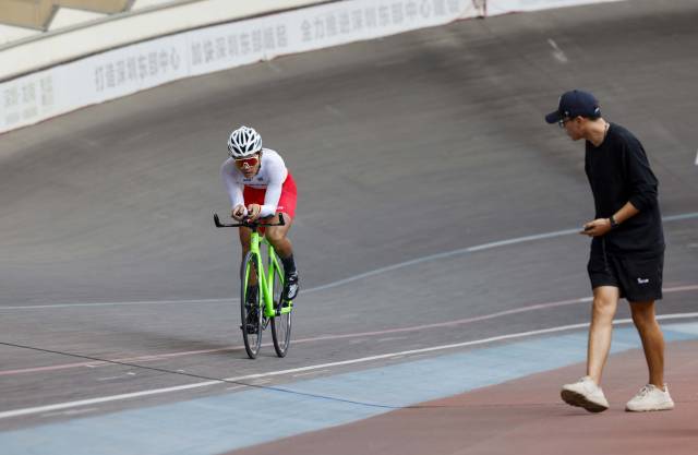 参赛选手在赛场上角逐骑行,教练正在打气助威。 参赛选手在赛场上角逐骑行,教练正在打气助威。